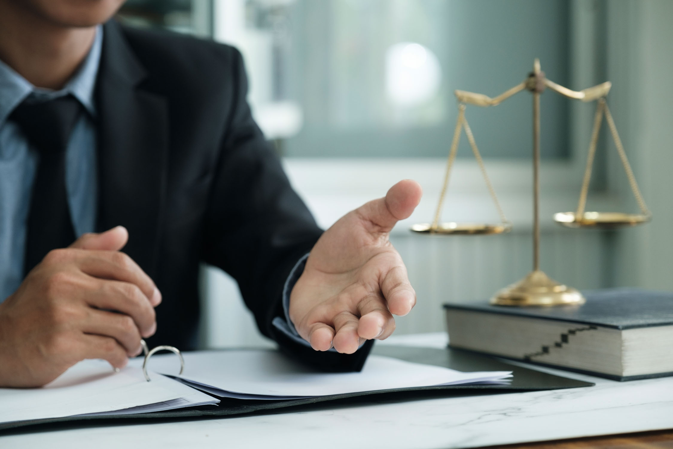 Male lawyer in the office with brass scale.